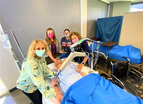 Four Bob Jones health sciences teachers circled around a robotic patient in a classroom 